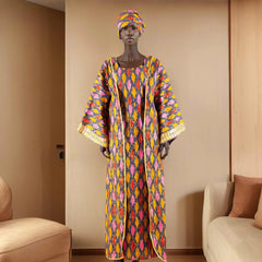 Mannequin wearing a colorful patterned dress and headscarf in a room with beige walls and furniture.