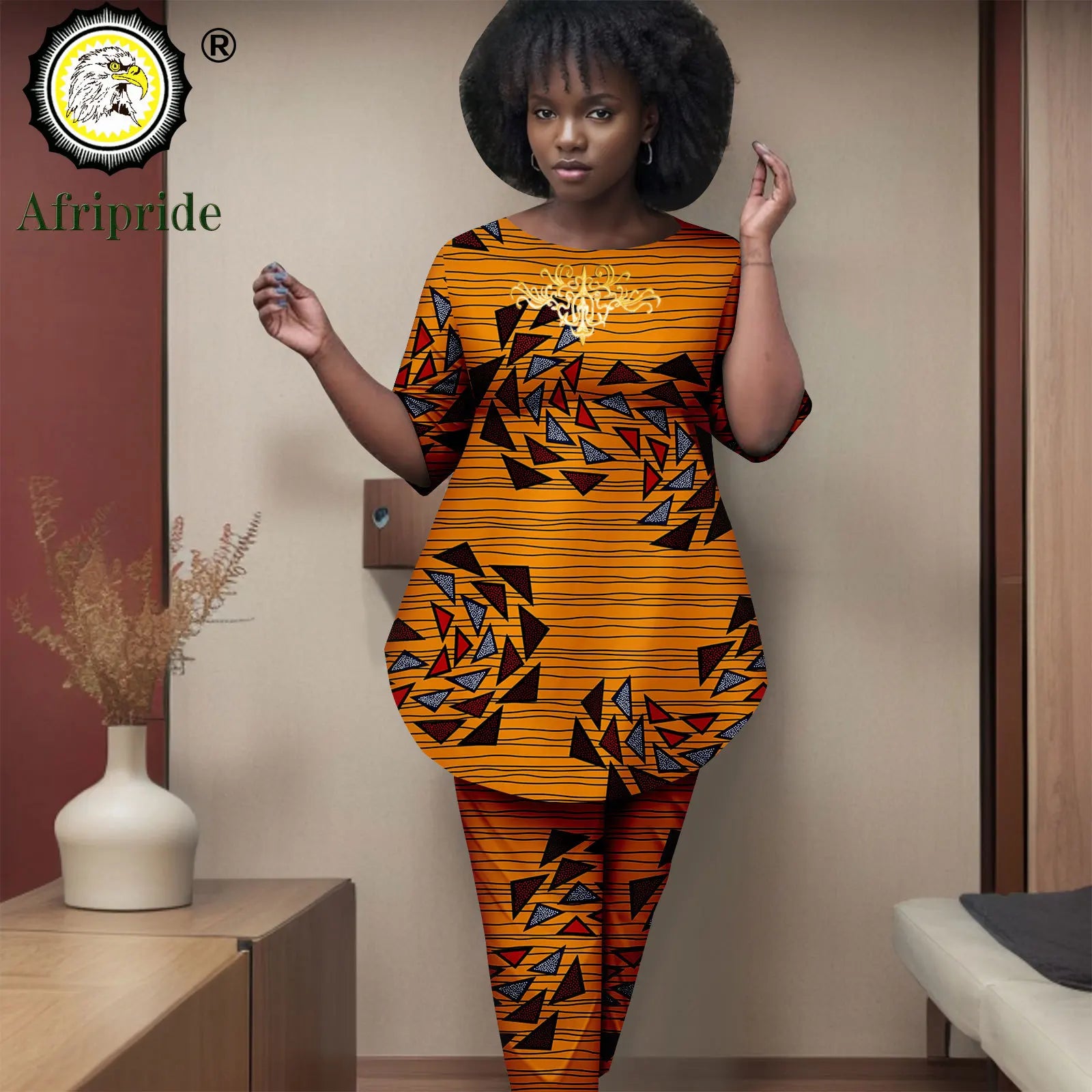 Woman wearing a colorful African print outfit with 'Afripride' logo.